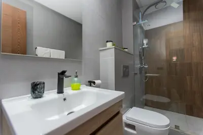 a bathroom with a white sink and a shower at Appartement cosy et moderne Bouskoura proche Aéroport et Hopital universitaire in Bouskoura