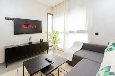 a living room with a couch and a tv at Appartement cosy et moderne Bouskoura proche Aéroport et Hopital universitaire in Bouskoura