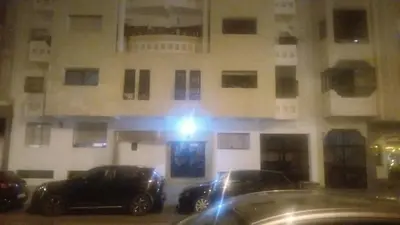 two cars parked in front of a building at night at best location single room in Casablanca