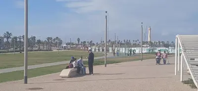 a group of people sitting on a bench in a park at best location single room in Casablanca