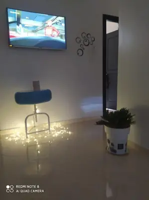 a blue chair sitting in a living room with a plant at Appartement neuf tres calme balcon vue sur l'océan in Skhirat