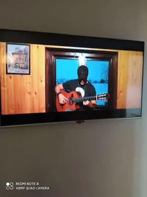 a tv screen with a man playing a guitar at Appartement neuf tres calme balcon vue sur l'océan in Skhirat