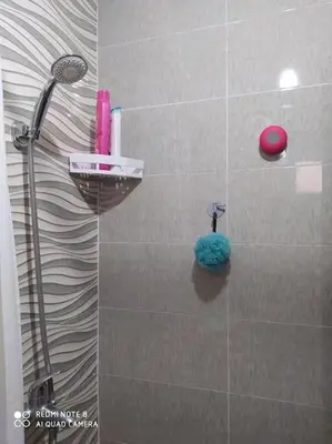 a bathroom with a shower with a blue rag on the wall at Appartement neuf tres calme balcon vue sur l'océan in Skhirat