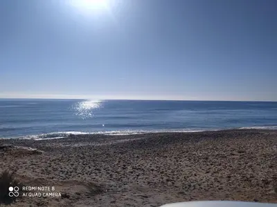 a view of the ocean from a sandy beach at Appartement calme in Skhirat