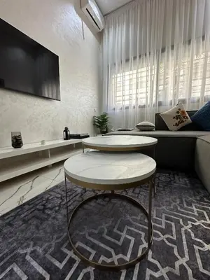 a living room with a table and a couch at Magnificent Cozy New Luxury Condo in Prime Casablanca Location in Les Camps