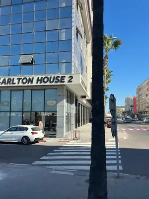 a car is parked in front of a building at Magnificent Cozy New Luxury Condo in Prime Casablanca Location in Les Camps