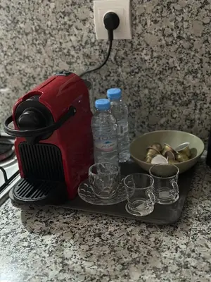 a toaster sitting on a counter with bowls and water bottles at Magnificent Cozy New Luxury Condo in Prime Casablanca Location in Les Camps