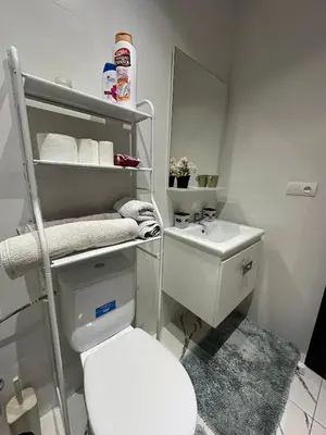 a bathroom with a white toilet and a sink at Magnificent Cozy New Luxury Condo in Prime Casablanca Location in Les Camps