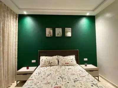 a green bedroom with a bed with two night stands at Luxury 3 Bedroom Apt Near Park and Sea, Heated Indoor Pool, Wifi, Free Parking in Casablanca