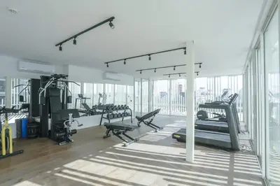 a gym with treadmills and machines in a room with windows at Résidence Luxuria - Rooftop Pool in Casablanca