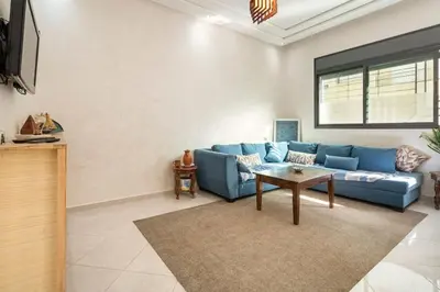a living room with a blue couch and a table at New appartement next to the beach Sidi Rahal in Sidi Rahal