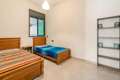a bedroom with two beds and a window at New appartement next to the beach Sidi Rahal in Sidi Rahal