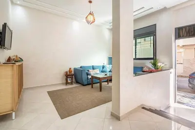 a living room with a blue couch and a table at New appartement next to the beach Sidi Rahal in Sidi Rahal