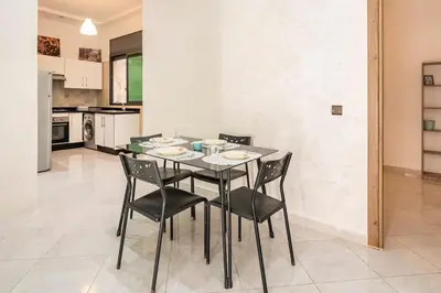 a dining room with a table and chairs in a kitchen at New appartement next to the beach Sidi Rahal in Sidi Rahal