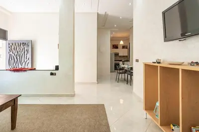 a living room with a flat screen tv on a wall at New appartement next to the beach Sidi Rahal in Sidi Rahal
