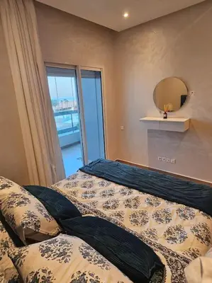 a bedroom with a bed and a mirror at Sidi Rahal Front mer, piscine & accès direct plage in Dar Oulad Hajj Kassem