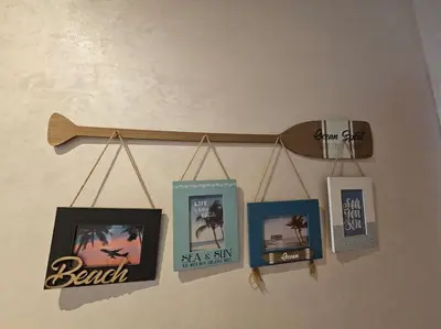 a wooden rail with pictures and a skateboard on a wall at Sidi Rahal Front mer, piscine & accès direct plage in Dar Oulad Hajj Kassem