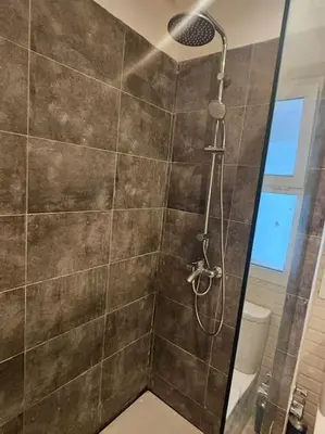 a bathroom with a shower with a glass door at Sidi Rahal Front mer, piscine & accès direct plage in Dar Oulad Hajj Kassem