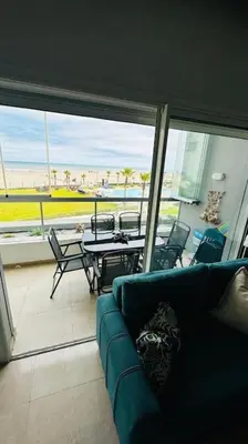 a living room with a couch and a table at Sidi Rahal Front mer, piscine & accès direct plage in Dar Oulad Hajj Kassem
