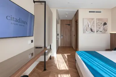 a hotel room with a bed and a flat screen tv at Citadines Almaz Aparthotel Casablanca in Casablanca