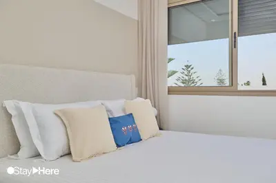a bed with white pillows sitting next to a window at StayHere Casablanca - Oasis - Premium Residence in Casablanca