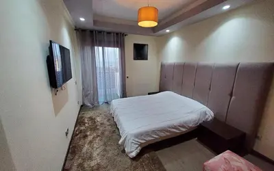 a bedroom with a bed and a tv on a wall at Appart chic vue Mer in Casablanca