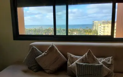 a couch with pillows sitting in front of a window at Appart chic vue Mer in Casablanca