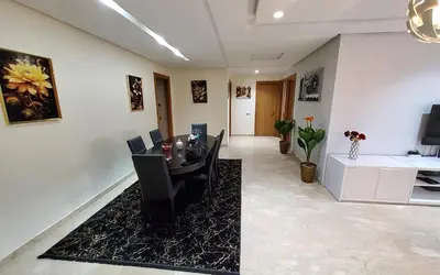 a living room with a table and chairs and a couch at Appart chic vue Mer in Casablanca