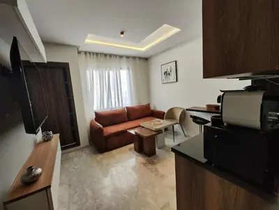 a living room with a couch and a table at Studio Palmiers Maarif in Casablanca