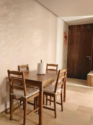 a wooden dining room table with chairs and a door at شقة فاخرة ومريحة في قلب الرباط in Rabat