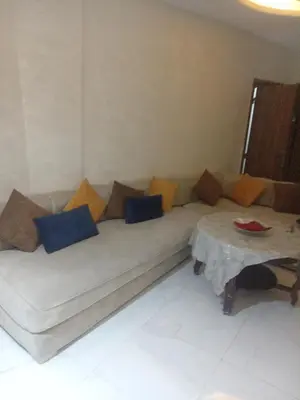 a couch with pillows and a table in a room at Basatin al firdaws in Ben Yakhlef