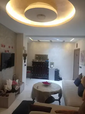 a living room with a table and a large ceiling at Basatin al firdaws in Ben Yakhlef