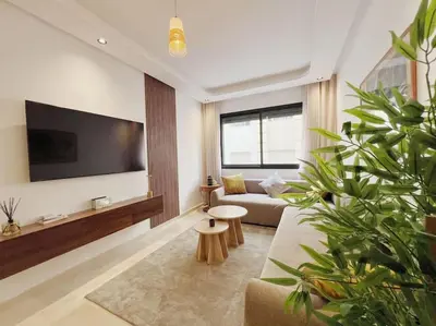 a living room with a couch and a flat screen tv at Résidence Acacias Casablanca in Casablanca