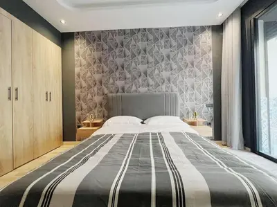 a large bed in a bedroom with a wall at Résidence Acacias Casablanca in Casablanca