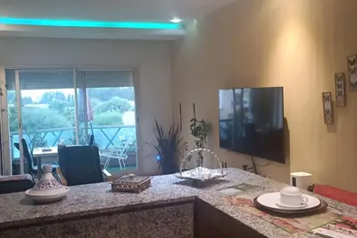 a kitchen with a counter top with a tv and a table at Suite Meublée à Nouaceur in Nouaceur