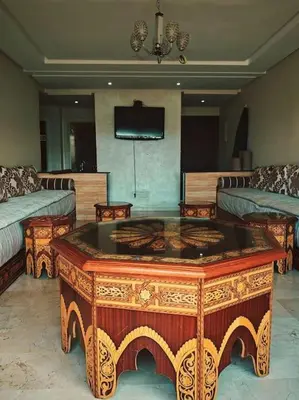 a living room with a table and a tv at Appartement au Bord de Mer in Casablanca