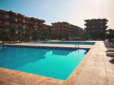 a large swimming pool with blue water in front of buildings at Appartement au Bord de Mer in Casablanca