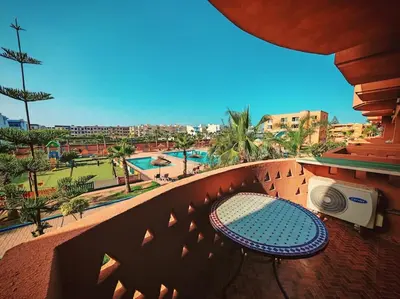 a balcony with a table and a view of a pool at Appartement au Bord de Mer in Casablanca