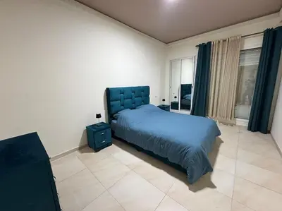 a bedroom with a blue bed and a window at Appartement moderne 2 chambres avec parking Agdal in Rabat