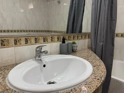 a white sink in a bathroom with a shower at Appartement moderne 2 chambres avec parking Agdal in Rabat