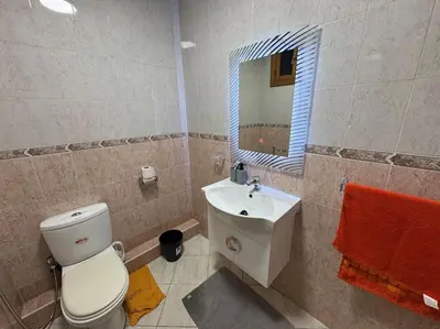 a bathroom with a toilet and a sink and a mirror at Appartement moderne avec parking - Proche Mall in Rabat