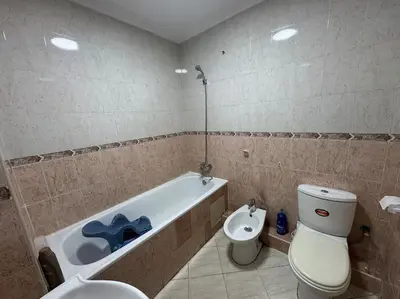 a bathroom with a tub and a toilet and a sink at Appartement moderne avec parking - Proche Mall in Rabat