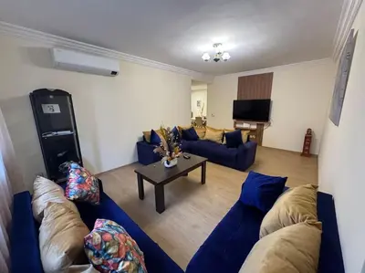 a living room with blue couches and a table at Appartement moderne avec parking - Proche Mall in Rabat