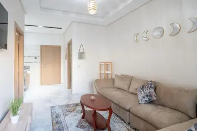 a living room with a couch and a table at Séjour Élégant et Détente au Bord de la Piscine in Aïn Harrouda
