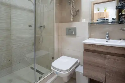 a bathroom with a shower and a toilet and a sink at Séjour Élégant et Détente au Bord de la Piscine in Aïn Harrouda