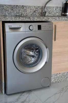 a washing machine in a kitchen next to a counter at Cosy appartement 2 BR avec vue panoramique piscine in Aïn Harrouda