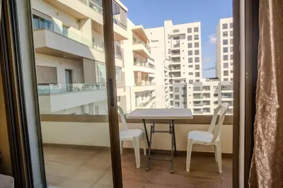 a table and chairs on a balcony with a view at Cosy appartement 2 BR avec vue panoramique piscine in Aïn Harrouda