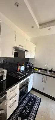 a kitchen with white cabinets and a stove top oven at 3 Bedroom apartment near Highway with parking in Casablanca