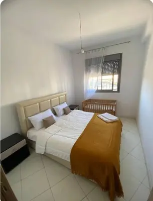 a bedroom with a large bed and a window at appartement neuf top quartier bouskoura a 2 min de l'Hôpital Universitaire International Mohammed 6 in Casablanca