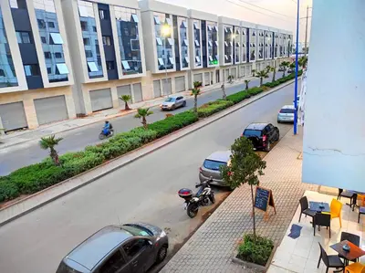 a street with cars parked on the side of a building at appartement neuf top quartier bouskoura a 2 min de l'Hôpital Universitaire International Mohammed 6 in Casablanca